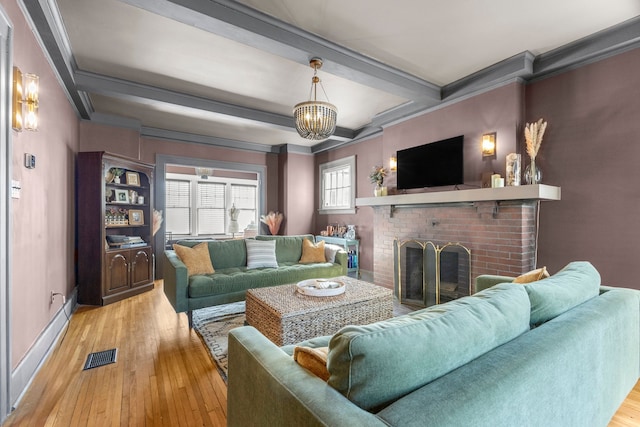 living area featuring visible vents, light wood-style flooring, beam ceiling, a fireplace, and a notable chandelier