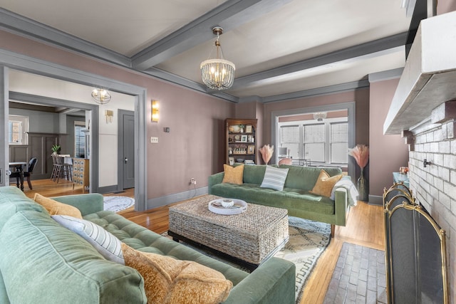 living area with beam ceiling, a notable chandelier, baseboards, and wood finished floors