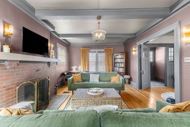 living room with beam ceiling, a fireplace, light wood-style flooring, an inviting chandelier, and baseboards