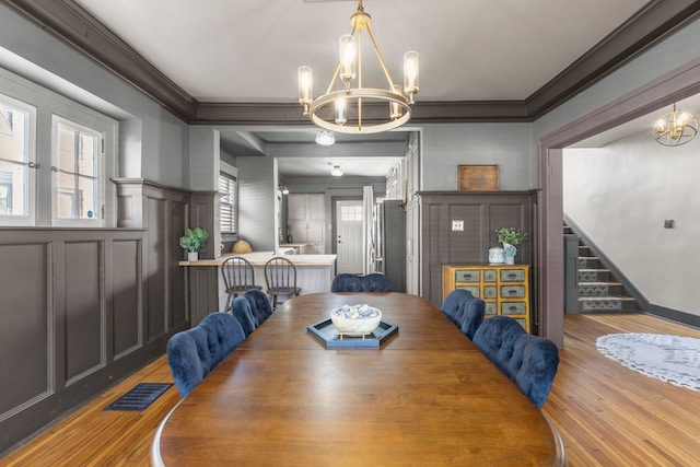 dining space featuring stairway, visible vents, a chandelier, and ornamental molding