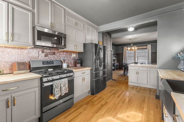 kitchen featuring stainless steel appliances, pendant lighting, and gray cabinets