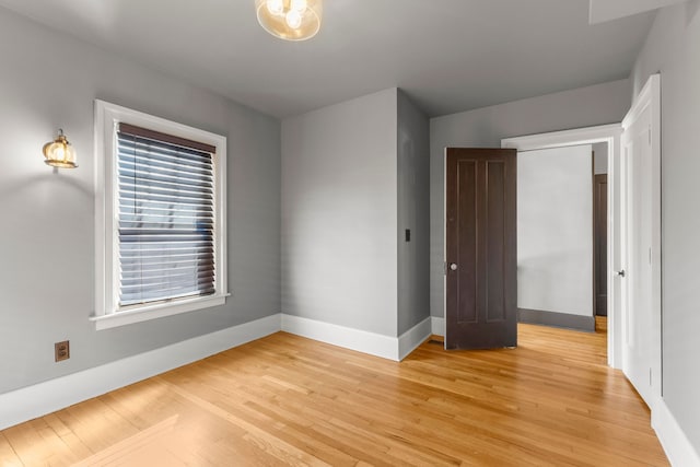 unfurnished bedroom with light wood-style flooring and baseboards