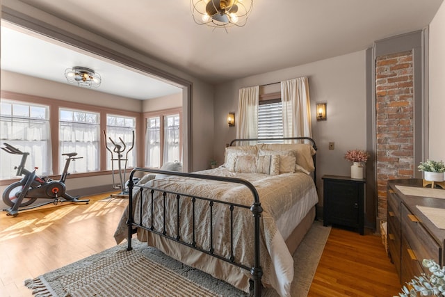 bedroom with multiple windows and wood finished floors