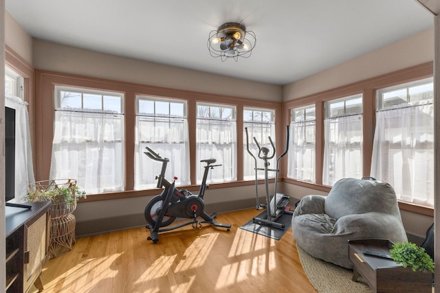 exercise room with light wood-style floors and baseboards