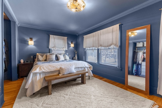 bedroom featuring a closet, ornamental molding, and wood finished floors