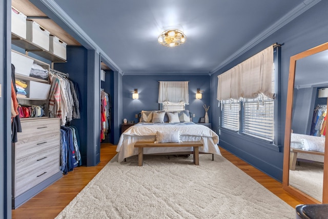 bedroom featuring light wood-style flooring, a closet, and crown molding