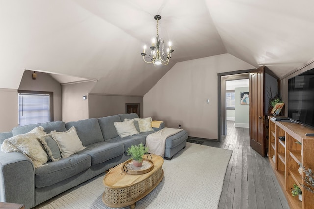 living room with lofted ceiling, baseboards, a chandelier, and dark wood finished floors