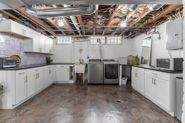 laundry room with laundry area, a toaster, electric panel, washer and clothes dryer, and a sink