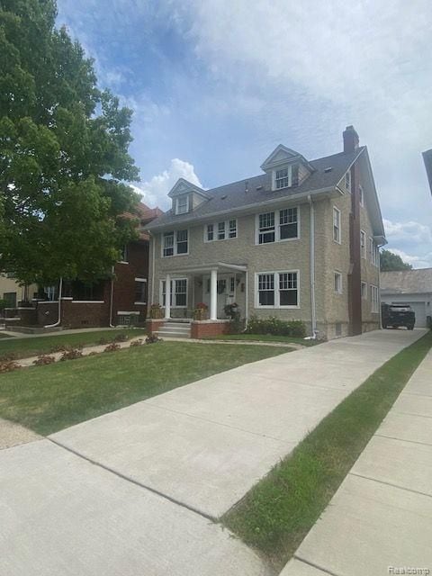 view of front of home with a chimney and a front lawn