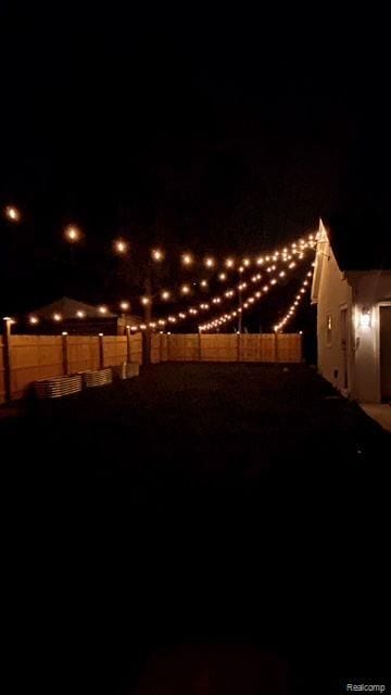 yard at night featuring fence