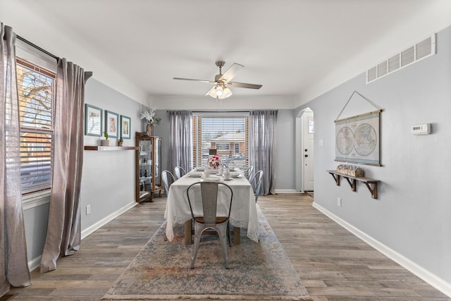 dining space with dark hardwood / wood-style floors and ceiling fan