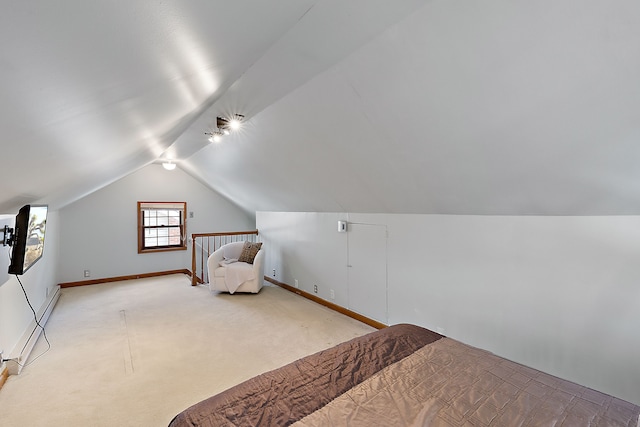 bedroom with baseboard heating, baseboards, vaulted ceiling, and light colored carpet