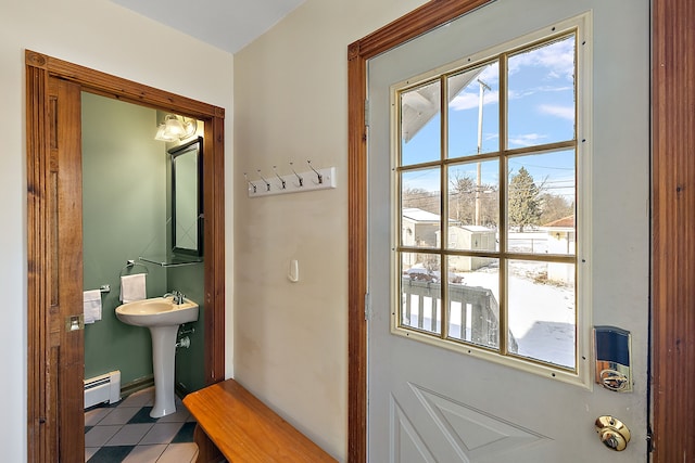 bathroom with baseboard heating, a sink, and tile patterned floors