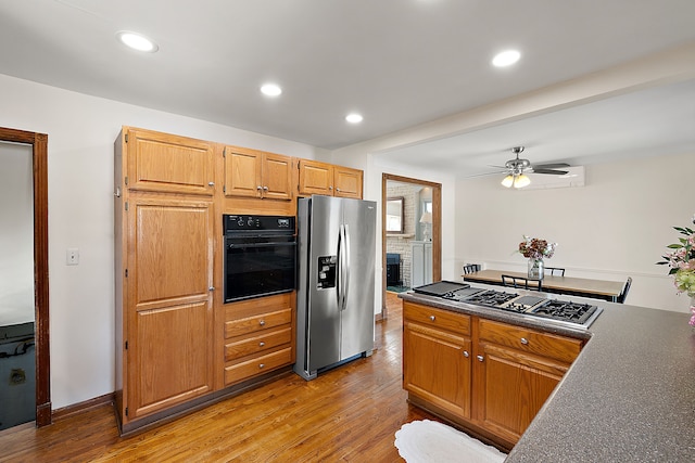 kitchen featuring a ceiling fan, dark countertops, appliances with stainless steel finishes, light wood-style floors, and recessed lighting