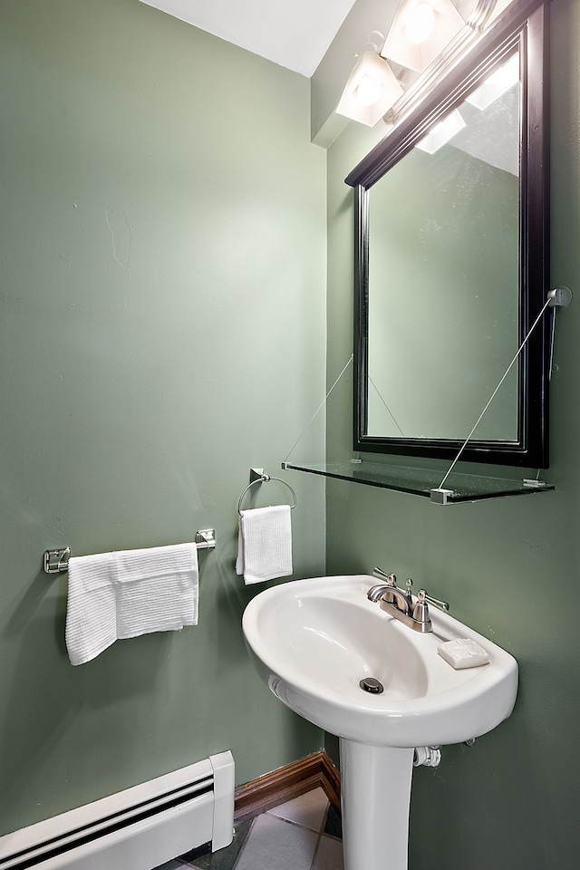 bathroom featuring baseboards, a sink, baseboard heating, and tile patterned floors