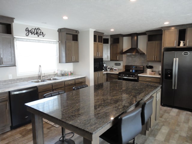 kitchen featuring stove, stainless steel fridge with ice dispenser, black dishwasher, sink, and wall chimney range hood