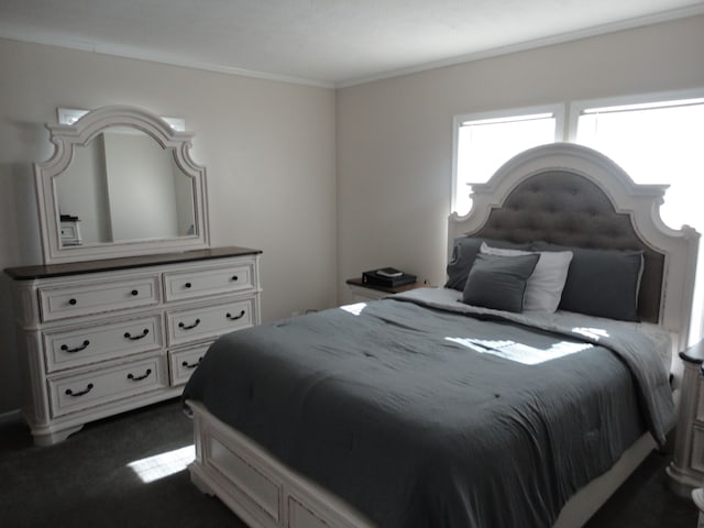 bedroom with dark colored carpet and ornamental molding