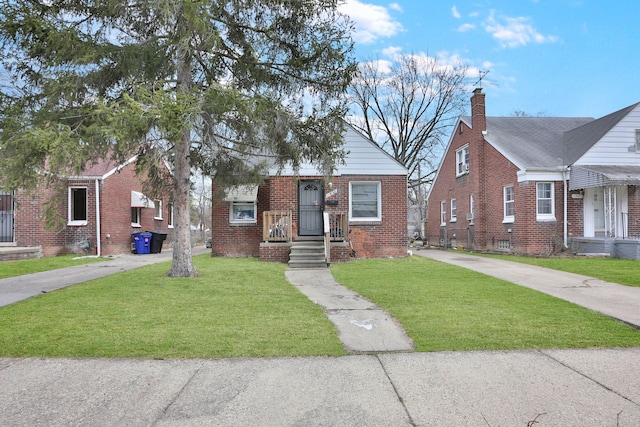 bungalow-style house with brick siding, concrete driveway, and a front yard