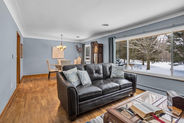 living room with a baseboard heating unit, crown molding, a notable chandelier, and wood-type flooring