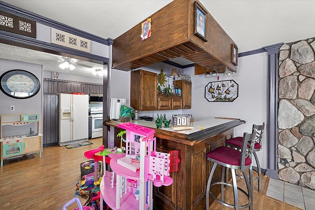 kitchen featuring ornamental molding, white appliances, and light wood-style flooring