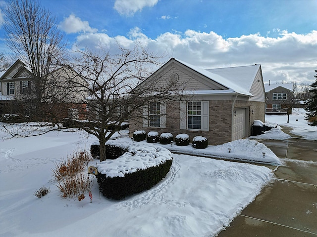 snow covered property with a garage