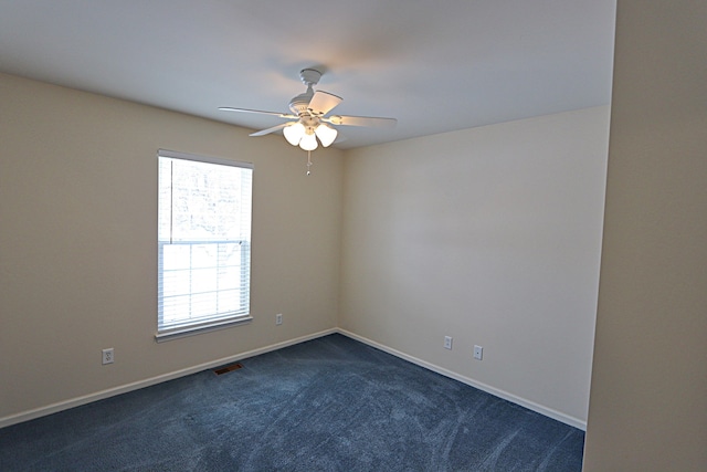 unfurnished room with ceiling fan and dark colored carpet