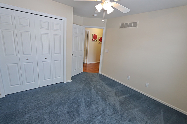 unfurnished bedroom featuring dark carpet, ceiling fan, and a closet