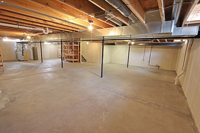 basement featuring heating unit and water heater