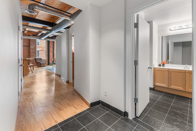 hallway featuring dark wood-type flooring and baseboards