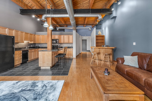 living area with wood ceiling, rail lighting, beamed ceiling, and a high ceiling