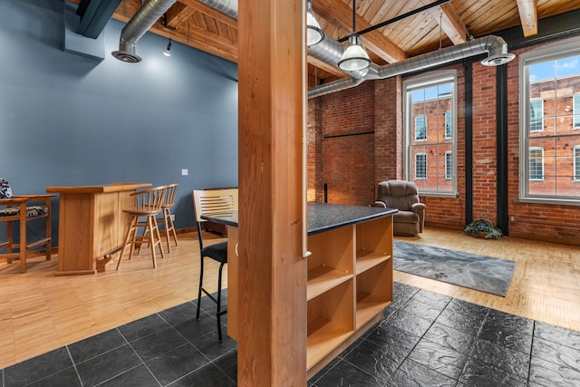 basement featuring brick wall, wooden ceiling, and baseboards