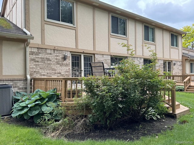 42201 Hidden Brook Dr Unit 68, Clinton Township, MI 48038 - rear view of property featuring brick siding, stucco siding, a wooden deck, and central air condition unit