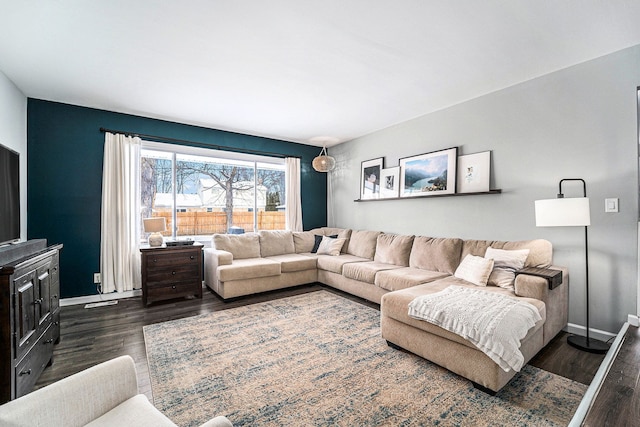 living area featuring baseboards and dark wood-type flooring