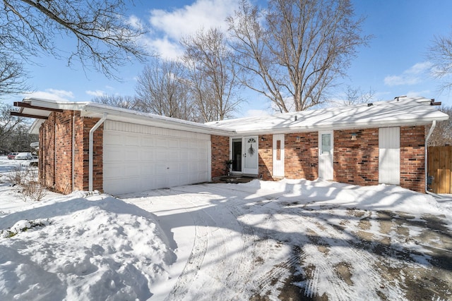 ranch-style home with brick siding, an attached garage, and driveway