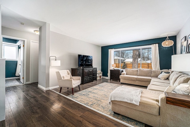 living room featuring baseboards and dark wood-style flooring