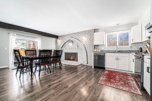 kitchen with gas range oven, hanging light fixtures, light stone countertops, black dishwasher, and white cabinetry