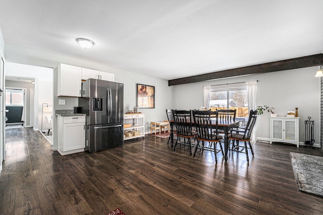 kitchen with dark wood-style flooring, baseboards, white cabinets, and stainless steel fridge