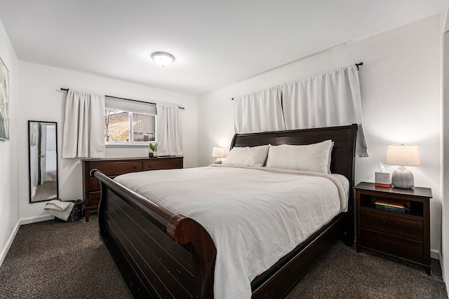 bedroom with baseboards and dark carpet