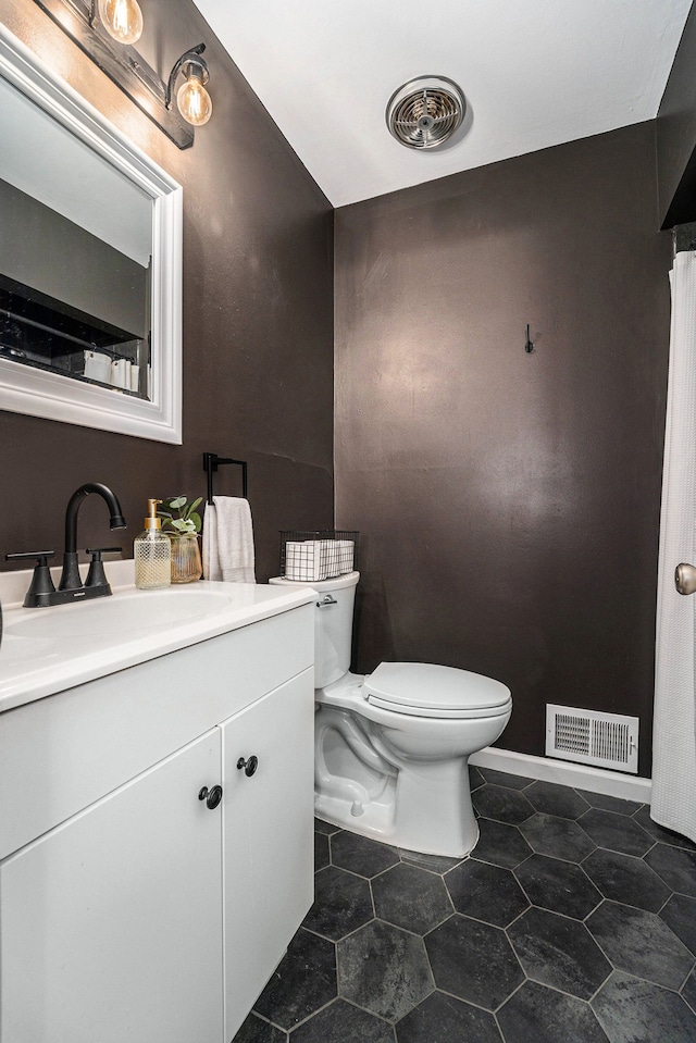 bathroom featuring visible vents, toilet, vanity, and tile patterned floors