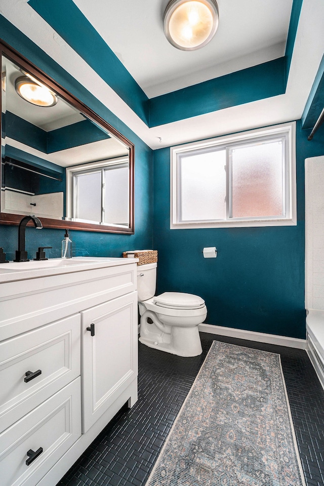 bathroom featuring vanity, toilet, and baseboards