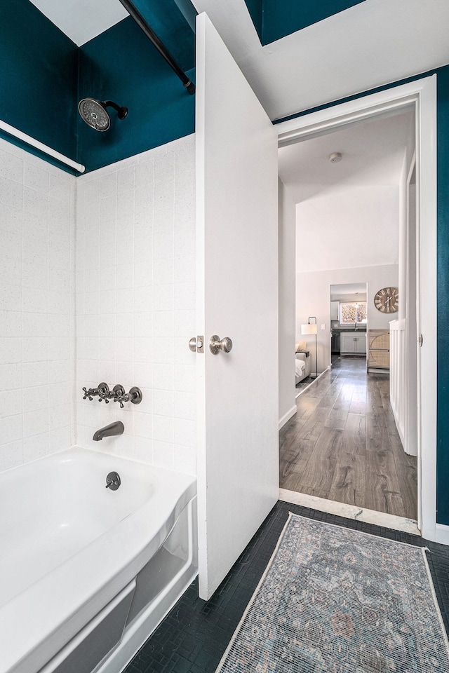 bathroom featuring shower / bath combination, baseboards, and wood finished floors