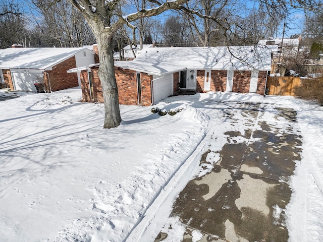 view of front of home featuring fence, brick siding, and a detached garage