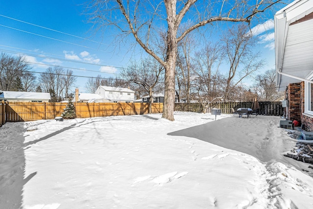 yard layered in snow featuring a fenced backyard