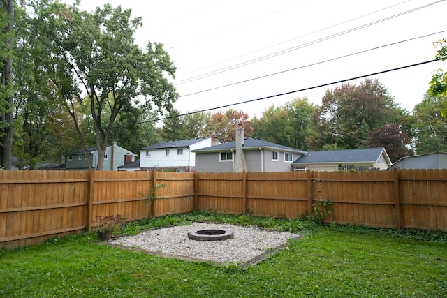 view of yard with a fenced backyard and a fire pit