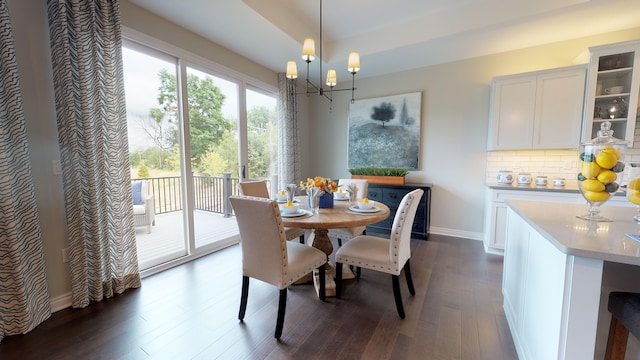 dining room with dark hardwood / wood-style floors and a notable chandelier