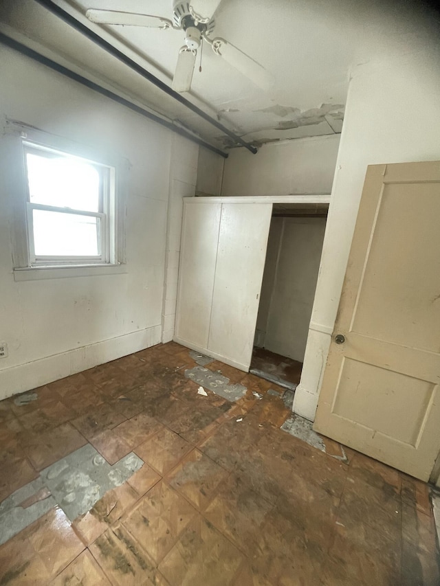 unfurnished bedroom featuring ceiling fan and a closet