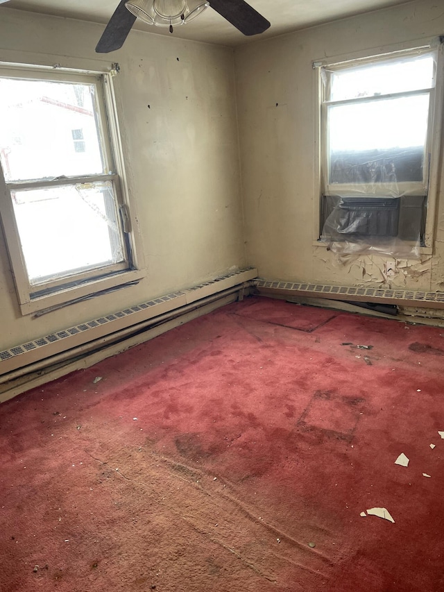 carpeted empty room featuring ceiling fan and a baseboard radiator