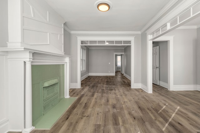 interior space featuring ornamental molding, a tile fireplace, and wood-type flooring