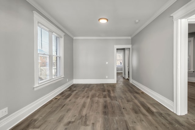 spare room with crown molding and dark wood-type flooring