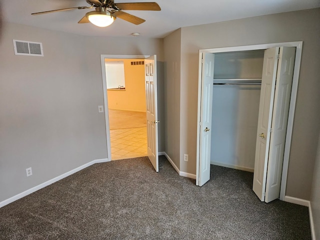 unfurnished bedroom with a ceiling fan, visible vents, baseboards, a closet, and dark carpet